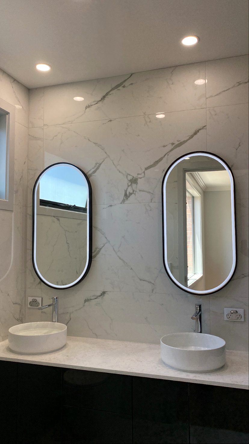 Bathroom with two LED-backlit mirrors, downlights and powerpoints installed above a double vanity