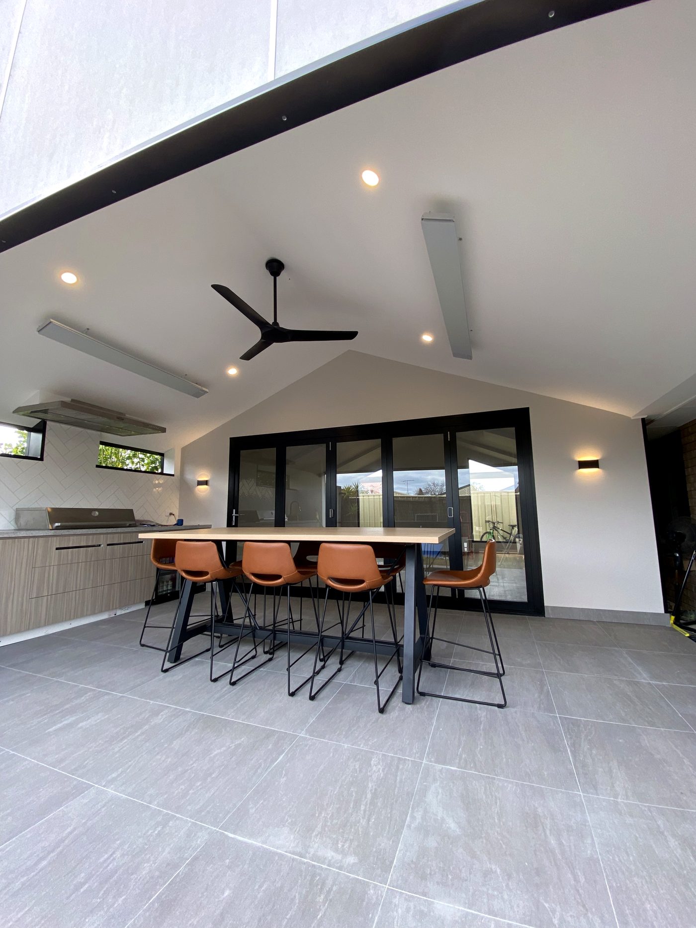 Outdoor alfresco area with a ceiling fan, downlights and wall lights installed
